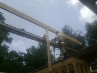 Carpenter setting a ridge beam over a new addition frame — Ice Dam Removal by Roofing Brothers in Stratton